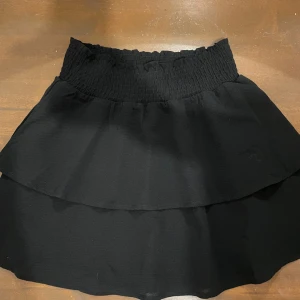 Svart volangkjol - Kort svart volangkjol från Only i strl 36, har resårband i midjan vilket gör den väldigt stretchig💓