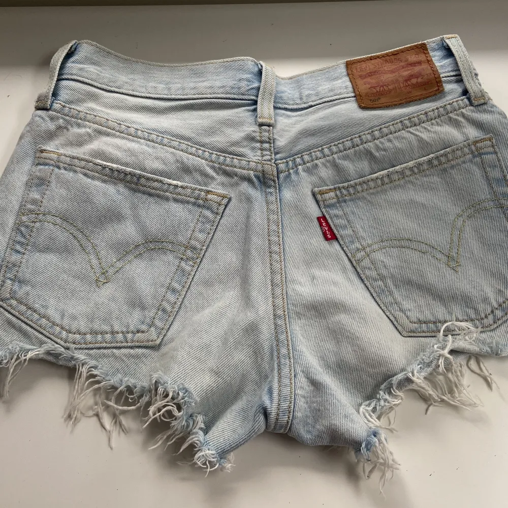 Levis jeans shorts i bra skick. Ljusblåa med silver och koppar knappar. Beige/ljusgula sömmar. Ganska korta.. Shorts.