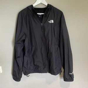 North Face vindjacka - Riktigt schysst North Face vindjacka med lite avslappnad passform. Den är riktigt skön när det regnar och håller ute allt regn då den är vattentät.  Kvitto kan ordnas! Skick 10/10 då den blivit sparsamt använd.