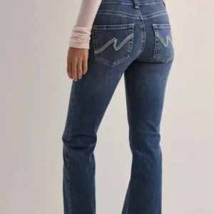 Blå bootcut jeans från nelly🤍 - Snygga blå bootcut jeans med hög midja och coola broderade detaljer på bakfickorna. Perfekta för en avslappnad stil med en touch av retro.