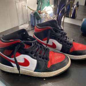 Nike Air Jordans i rött, svart och vitt - Snygga Nike Air Jordans i en klassisk färgkombination av rött, svart och vitt. Har ej kommit till användning på ett bra tag 