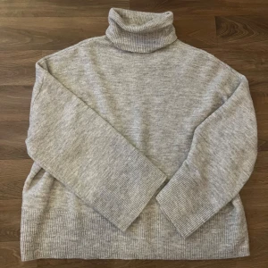 Grå stickad polotröja från Bikbok - Ljus grå stickad tröja med krage. Endast använd en gång 
