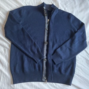 Full zip cardigan med knappar  - Snygg unik merinoull cardigan som har både hel zip och knappar från malagrida. Hör av dig vid funderingar!