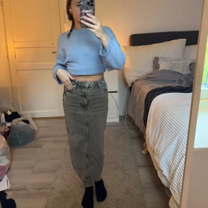 Grå jeanskjol med slits - Säljer en stilren grå jeanskjol med en slits baktill. Kjolen har en klassisk design med fickor. Perfekt för en avslappnad look. Storlek 34, aldrig använd då det va den ända som fanns kvar men den går precis att stäng så sitter inte så bekvämt på mig! Prislapp kvar!
