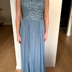 Blå långklänning från Lace & Beads - Elegant blå långklänning från Lace & Beads med glittrig paljettöverdel och plisserad kjol. Perfekt att ha som t.ex balklänning osv!! Jag är 160 och den sitter perfekt med klackar!! Hör av er vid frågor🎊🎊💙💙💙