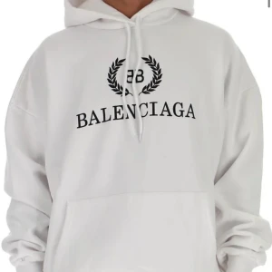 Vit hoodie från Balenciaga - Säljer en stilren vit hoodie från Balenciaga med svart logotyp och kransdetalj på bröstet. Vill du ha fler bilder så skriv! 