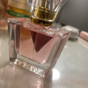 Guess Seductive Kiss Parfym - Elegant parfym från Guess med en förförisk doft. Flaskan är stilrent designad i glas med en rosa vätska och en gyllene detalj på korken. Perfekt för den som vill ha en touch av lyx i vardagen. PRIS KAN DISKUTERAS VID SNABB KÖP