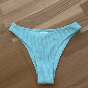 Mintgröna bikiniunderdelar från H&M - Aldrig använda!! Snygga mintgröna bikiniunderdelar från H&M i en ribbad design. Perfekta för sommarens stranddagar. Modellen är cheeky