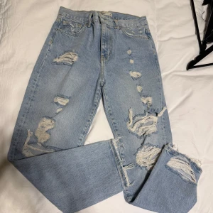 Ljusa jeans med slitningar - Snygga ljusa jeans med coola slitningar för en trendig look. De har en klassisk femficksdesign och knappgylf. Perfekta för en avslappnad stil.