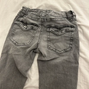 Gråa low waist boot cut jeans - Jätte fina gråa low waist jeans från Gina tricot i storlek 152, jag säljer dessa byxor därför att de är lite för tighta och för korta på mig. Priset kan diskuteras!