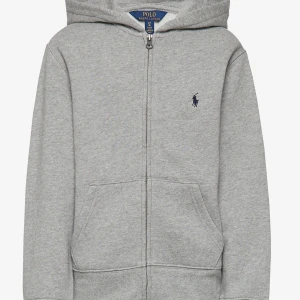 Grå hoodie från Polo Ralph Lauren - Säljer en klassisk grå hoodie från Polo Ralph Lauren med dragkedja och huva. Tröjan har en broderad logotyp på bröstet och praktiska fickor framtill. Kontakta för fler bilder!! 