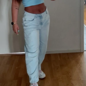 Ljusblå jeansbyxor - Snygga ljusblå jeansbyxor med en avslappnad passform. Byxorna har en klassisk femficksdesign och knappar framtill. Perfekta för en casual look.