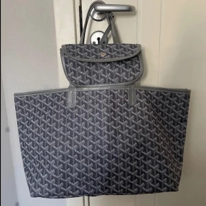 Grå mönstrad väska - Snygg grå shoppingväska med ett fint mönster. Väskan har två handtag och en matchande avtagbar liten väska med knappstängning. Köpt för 900kr på en secondhand affär i Spaninen, aldrig använt och har inga defekter❤️Perfekt för att bära med sig allt man behöver under dagen. Säljer samma i grön också! Kan gå ner i pris vid snabb affär!