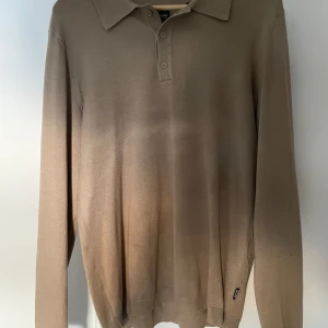 Beige pikétröja från Only & Sons - Snygg beige pikétröja från Only & Sons med klassisk krage och knappar framtill. Tröjan har långa ärmar och är perfekt för en stilren look. Tillverkad i ett mjukt material som ger en bekväm passform.