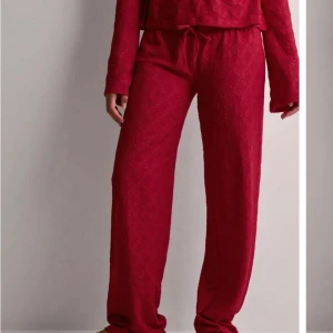 Röda stickade byxor - Snygga röda stickade byxor från Nelly. Byxorna har en fin  passform och är använda endast en gång. .