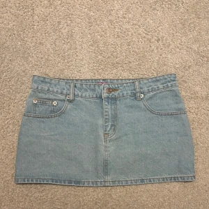 Ljusblå jeanskjol från Edikted - Trendig ljusblå jeanskjol från Edikted i kort modell. Kjolen har klassisk femficksdesign och bälteshällor. Perfekt för en avslappnad och stilren look. Helt ny bara provad. Pris går att diskutera!