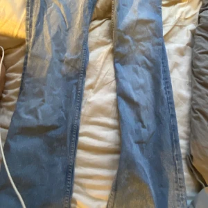 Blå jeans från H&M Divided - Snygga blå jeans från H&M Divided med klassisk femficksdesign och knappgylf. Perfekta för en avslappnad stil💗💗