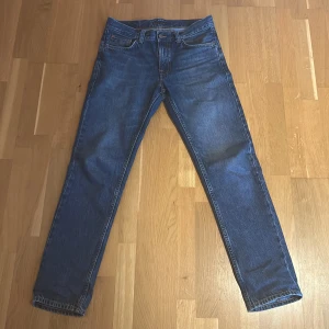 Blå jeans från Nudie Jeans - Snygga blå jeans från Nudie Jeans i modellen Gritty Jackson. De har en klassisk femficksdesign och är tillverkade i 100% bomull. Perfekta för en avslappnad stil med en straight passform.
