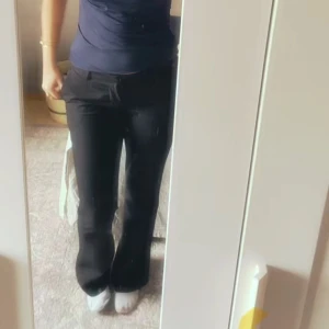 Svarta kostymbyxor med slits  - Snygga svarta kostymbyxor med slits från bik bok. Pytte lite slitet på vänster ben på kanten men inget som syns eller man lägger märke till. Midjemått är tvärs över 38,5