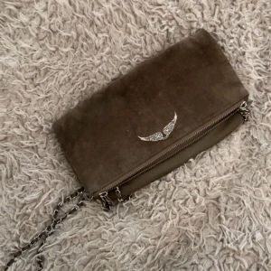 ZADIG VÄSKA - Brun mocka axelväska med kedja från Zadig & Voltaire. Köpte på Vestaire för ca 2 år sedan men har inte använts mycket alls, dock mockan lite färgskadad. Köpte för 1400kr.