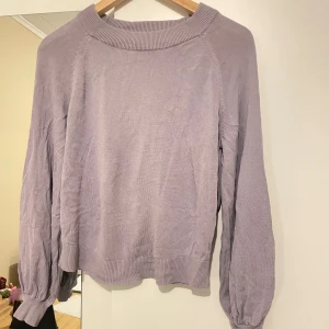 Lila stickad tröja från kappahl - Mysig lila stickad tröja med långa ärmar och ribbade muddar. Perfekt för kyligare dagar och ger en avslappnad look. Passar bra till jeans eller kjol för en stilren outfit.