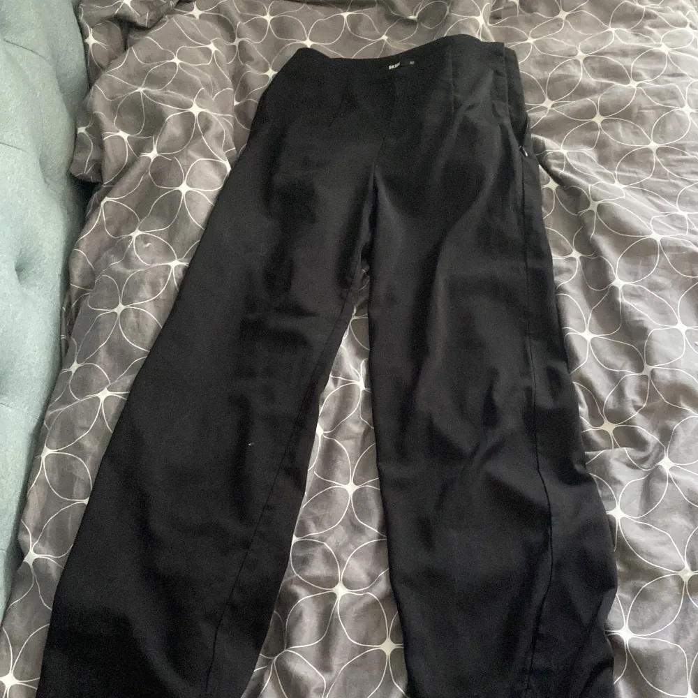 Snygga svarta byxor från Bik Bok i storlek XS. De har en klassisk design med en rak passform och är perfekta för en stilren look. Byxorna är tillverkade i ett mjukt material som ger en bekväm känsla hela dagen.. Farkut & Housut.