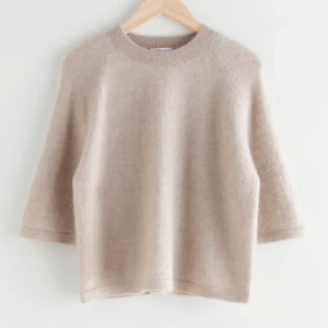 Snygg kortärmad stickaf tröja  - Säljer denna tröjan då den inte längre kommer till användning det är en beige stickad tröja från other stories i storlek s. Säljer lågt pris pågrund av det lilla ”hålet” på sista bilden. Syns inte när man har på sig tröjan