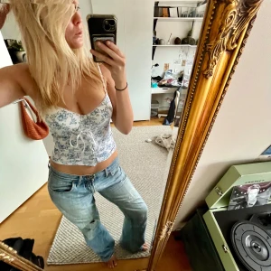 Blommig korsett med snörning - Säljer en superfin blommig korsett i vitt och blått. Den har en tight passform och snörning. Köpt secondhand och om du har några fler frågor är det bara att kontakta mig 🌸