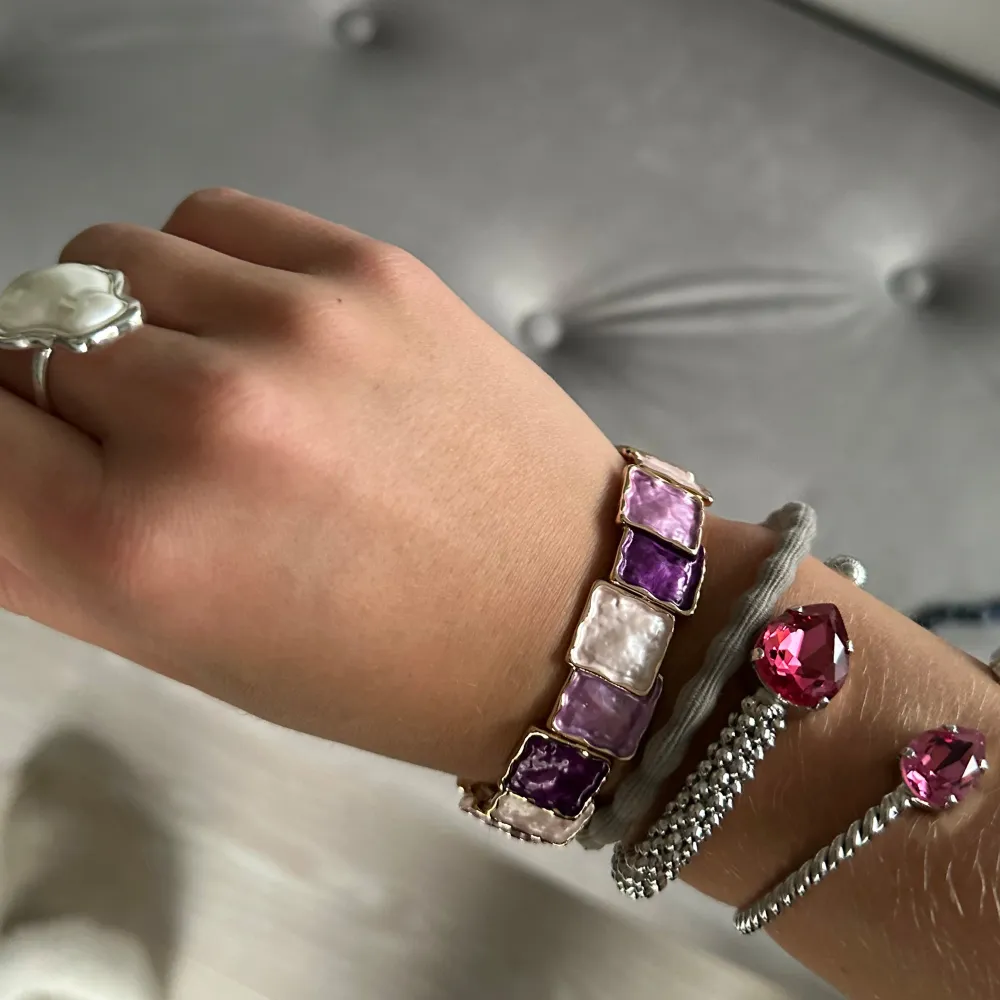 Säljer ett supercoolt armband med stora fyrkantiga stenar i lila och rosa nyanser. Armbandet har en guldig bas. Köptes i en lokal butik i frankrike för 550kr, de sa att det var 18 karat på armbandet. jag har använt mkt o de håller jättebra!!. Accessoarer.