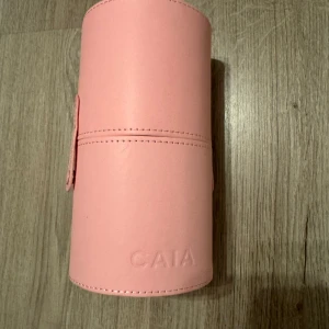 Caia fodral  - Rosa fodral till sminkborstar från Caia. Helt nytt och oanvänt, finns dock en brun fläck i öppningen som var där när den köptes med vet int om den ska vara där. 