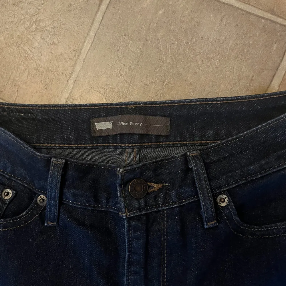 Säljer ett par mörkblå skinny jeans från Levi's. De är i bra skick och har en klassisk femficksdesign med knapp och dragkedja framtill. Perfekta för både vardag och fest!. Jeans & Byxor.