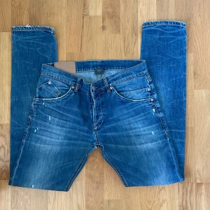 Dondup - Riktigt schyssta Dondup jeans i storlek 33. Med unika goa slitningar o unikt dondup märke broderat på vänstra låret.