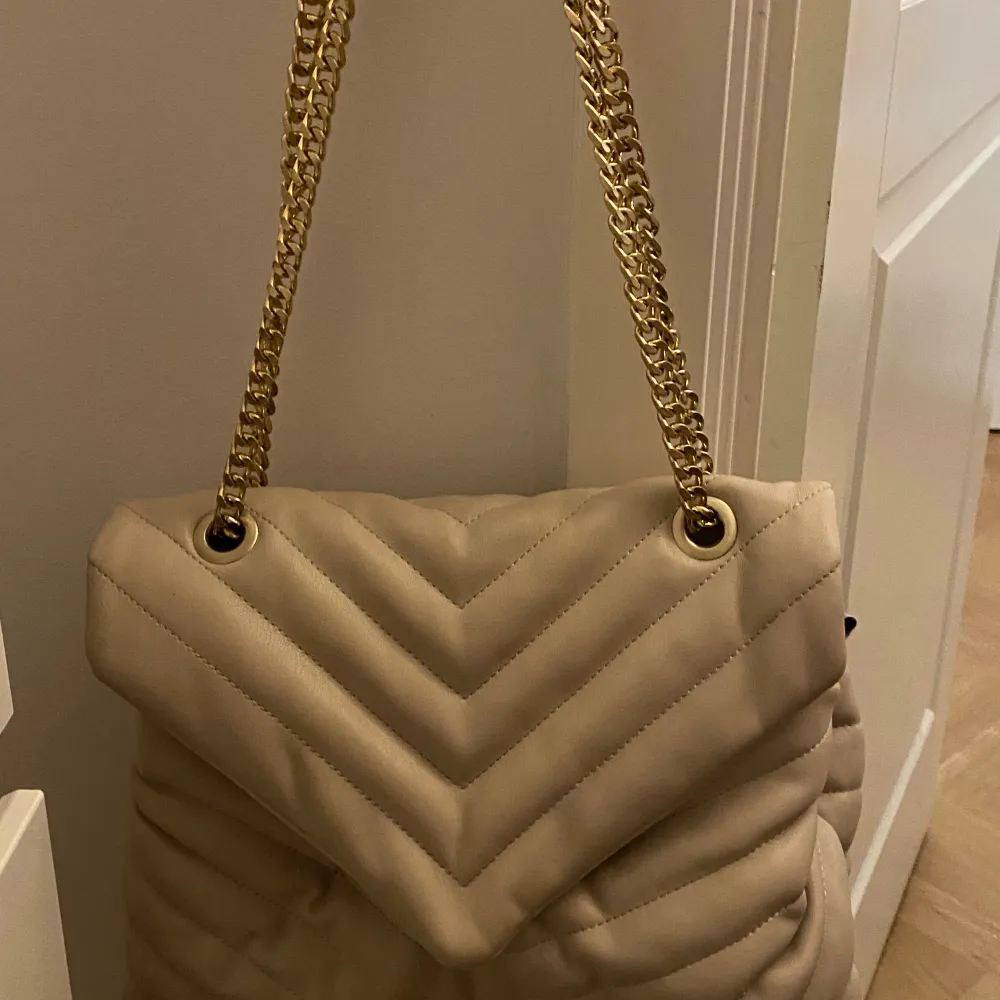 Säljer en superfin beige axelväska från Parfois. Den är quiltad med ett snyggt mönster och har en elegant guldkedja som axelrem.💞säljer pga för många väskor💞💞. Väskor.