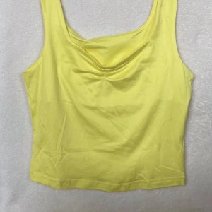 Gul topp - Gul söt topp. Toppen är rynkad vid bröstet vilket ger en söt detalj!!  Passar till alla tillfällen och är använd sparsamt💛💛
