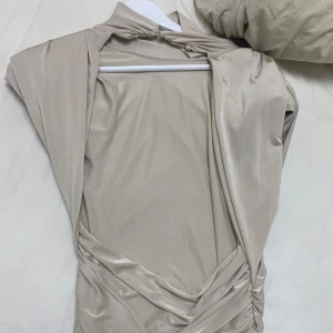 Satin klänning - Jätte elegant satin klänning i champagne färg stilig med små armpuffar och volang. Öppen rygg på klänningen också. Storlek S. Köpt från Zara 2 år sen använt 2 gånger men den är i nytt skick. Nypris 699kr