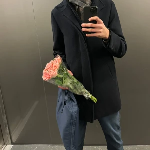 Blå kappa från brothers  - Säljer min medellånga blåa Riley kappa från brothers. Den är ny och använd fåtal gånger, perfekt skick och modellen på bilden är 183 cm lång. Fint material med en inbyggd väst som gör att den håller kappan på plats. Köpt från brothers nypris 2799