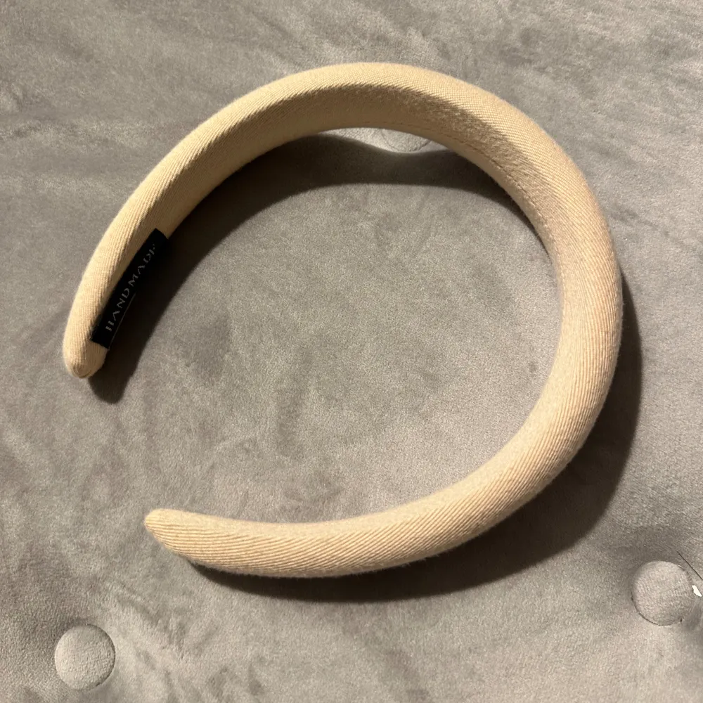 Säljer ett stilrent och enkelt beige diadem. Perfekt för att ge en touch av elegans till vilken outfit som helst. Det är mjukt och bekvämt att bära hela dagen. Passar både till vardags och fest!. Asusteet.