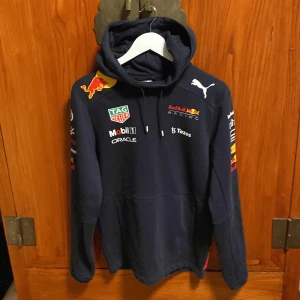 F1 redbull hoodie - Tjena säljer nu denna feta F1 redbull hoodie!! Säljer den eftersom jag ej kollar på F1 längre! Modellen på bilden är 175 och väger runt 67kg!💯 Skick 9/10 knappt använd👌🏼kan eventuellt gå ner en bit i pris vid snabb affär💪🏽