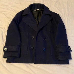 Mörkblå kappa - Jättefin mörkblå kappa från Design by Si. Som är perfekt nu till hösten. Den är i väldigt bra skick.