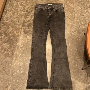 Grå bootcut jeans från Gina Tricot - Säljer ett par snygga grå bootcut jeans från Gina Tricot i storlek 36. De har en klassisk femficksdesign och är perfekta för både vardag och fest. Jeansen är i bra skick och har en skön passform som sitter snyggt över höfterna och släpper ut vid benen. Perfekta för dig som gillar en stilren look!