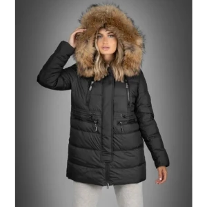 Svart dunjacka med pälsdetalj - Säljer en snygg svart dunjacka med mysig pälsdetalj på huvan. Jackan har dragkedja och knappar framtill, perfekt för kalla vinterdagar. Den är i bra skick och håller dig varm och stilren. Passar perfekt för både vardag och festliga tillfällen.