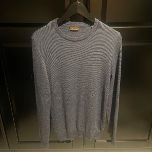 Stenströms tröja - Säljer en stilren och bekväm grå tröja i 100% merinoull från stemströms. Perfekt för kyliga dagar med sin mjuka och värmande kvalitet. Tröjan har en klassisk design med rund hals och långa ärmar. Passar både till vardags och lite finare tillfällen.