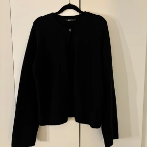 Svart kofta från Gina Tricot - En svart stickad kofta med en knapp upptill från Gina tricot. Vida ärmar och bara använd ett par gånger. Storlek XL men jag som vanligtvis bär S/M tycker att den har en perfekt passform. Nypris 360 kr.