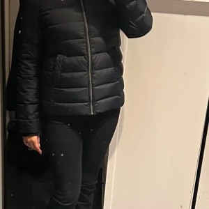 Svart dunjacka från Tommy Hilfiger - Säljer en snygg svart dunjacka från Tommy Hilfiger i storlek S. Jackan har en dragkedja framtill och en praktisk huva. Perfekt för kyliga höst- och vinterdagar. Den är i mycket bra skick och redo för nya äventyr! 🖤