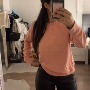 Rosa sweatshirt från Adidas - Säljer en superfin rosa sweatshirt från Adidas. Den har en diskret logga på framsidan och är perfekt för en avslappnad stil. Tröjan är långärmad och gjord i mjukt material, vilket gör den både bekväm och snygg. Passar perfekt till vardags eller chill dagar hemma. 💖