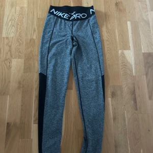 Grå Nike Pro leggings - Säljer ett par grå Nike Pro leggings i mycket bra skick. De är använda endast 3 gånger eftersom de nu inte längre passar