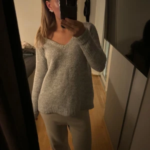 VILA stickad tröja - Mjuk och mysig grå stickad tröja med v-ringning och långa ärmar. Tröjan är från vila och är i xs, perfekt för vinter och höst!