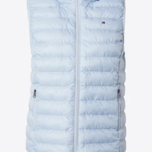 Ljusblå dunväst från Tommy Hilfiger - Säljer en snygg ljusblå dunväst från Tommy Hilfiger. Västen har en dragkedja framtill och två praktiska fickor med dragkedjor. Perfekt för kyliga dagar när du vill hålla stilen. Den är i mycket bra skick och passar perfekt för vår och höst.