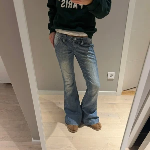 Blå lågmidjade bootcut jeans - Säljer ett par snygga blå bootcut jeans i bra skick. De är lågmidjade och har en klassisk femficksdesign med knapp och dragkedja fram. Perfekta för en avslappnad vardagslook eller en utekväll. Passar bra med sneakers eller boots! Sjukt snygga och populära💗😋🥹✨Midjemått: ca 36 cm rakt över och innerbenslängd: ca 79cm🥹🥹💗☺️🧘‍♀️