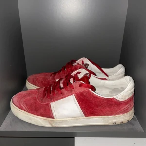 Valentino Flycrews  - Säljer ett par snygga röda valentino flycrews i mocka med vita detaljer. Storlek 44.5 i mycket använt skick! Slutsålda överallt där dem inte produceras något mer. Sprickor i skon finns därav priset.(stor spricka kolla sista bilden) Snygga som fan som går att använda till både fest och till vardags.